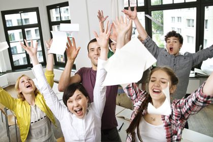 Photo of a happy people while throwing papers on air